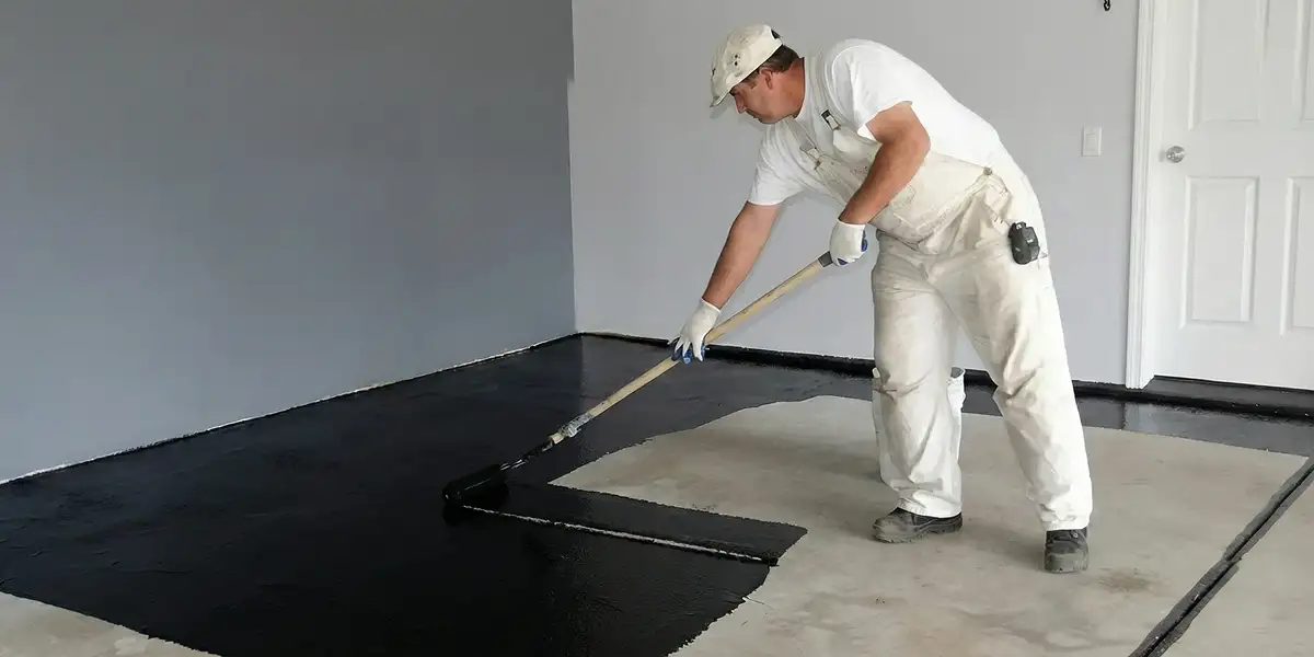basement waterproofing professional applying waterproof coating to protect a basement floor in Philadelphia, PA